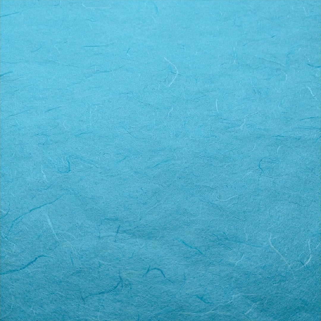 Kozo Studio Atoll Blue handmade paper in a close-up shot, showcasing the distinctive mulberry fibers and natural feel.