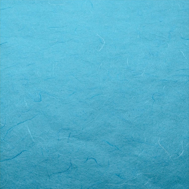 Kozo Studio Atoll Blue handmade paper in a close-up shot, showcasing the distinctive mulberry fibers and natural feel.