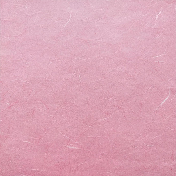 Detailed image of Kozo Studio Classic Pink handmade paper with visible mulberry fibers and natural shadows.