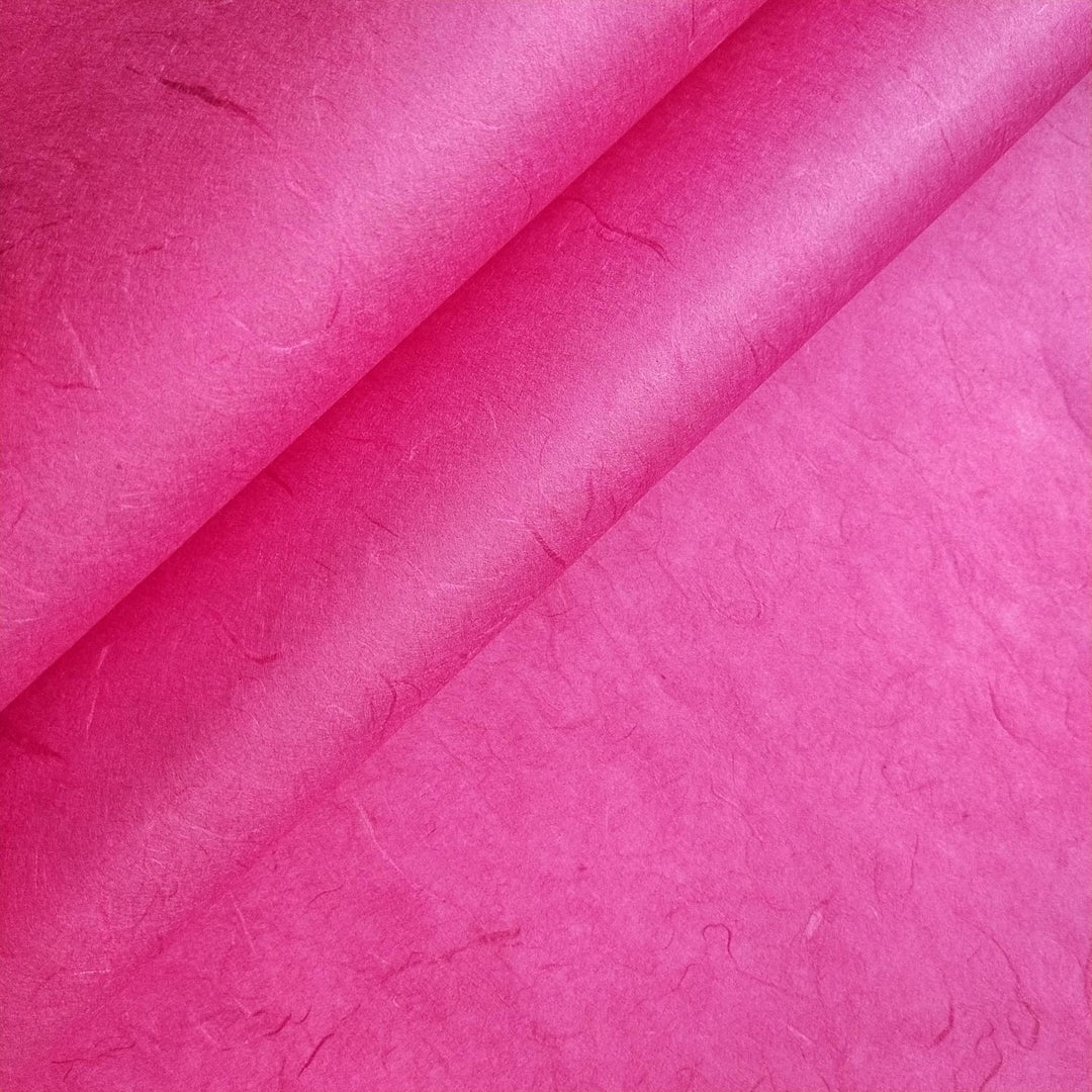 Close-up of folded Unryu Kozo Paper (Fuchsia) by Kozo Studio, highlighting subtle fibers and a crinkled texture.