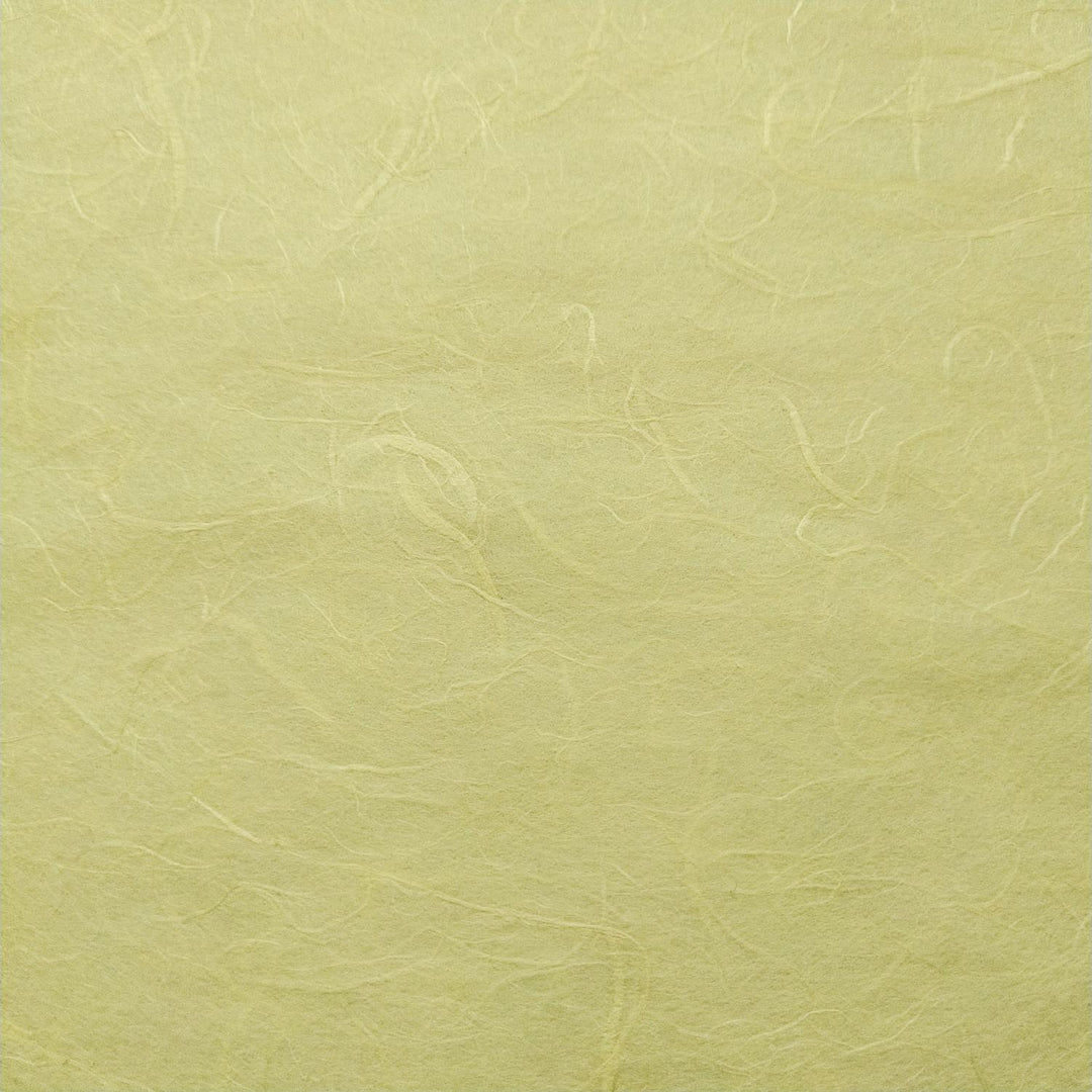 Detail of handmade paper by Kozo Studio in lemon yellow, highlighting the fibrous structure of mulberry paper with soft natural folds.