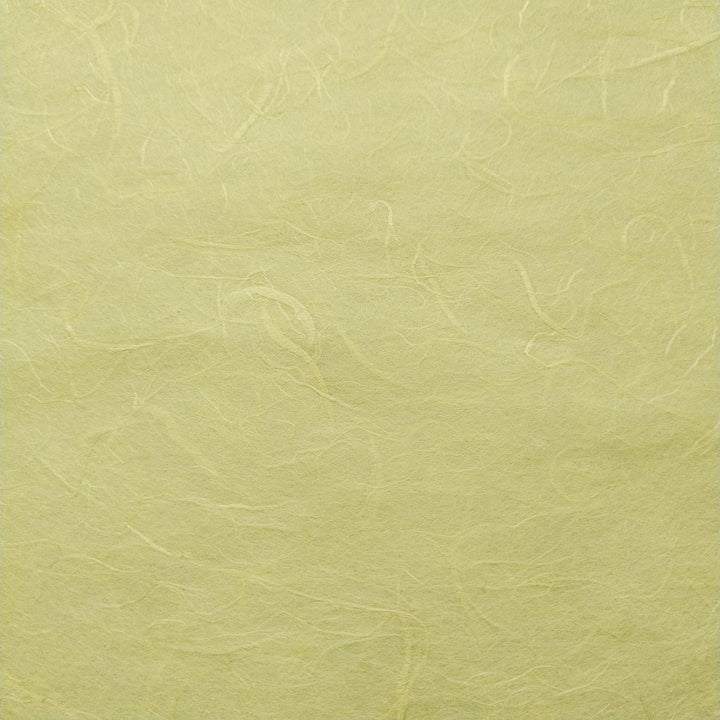 Detail of handmade paper by Kozo Studio in lemon yellow, highlighting the fibrous structure of mulberry paper with soft natural folds.