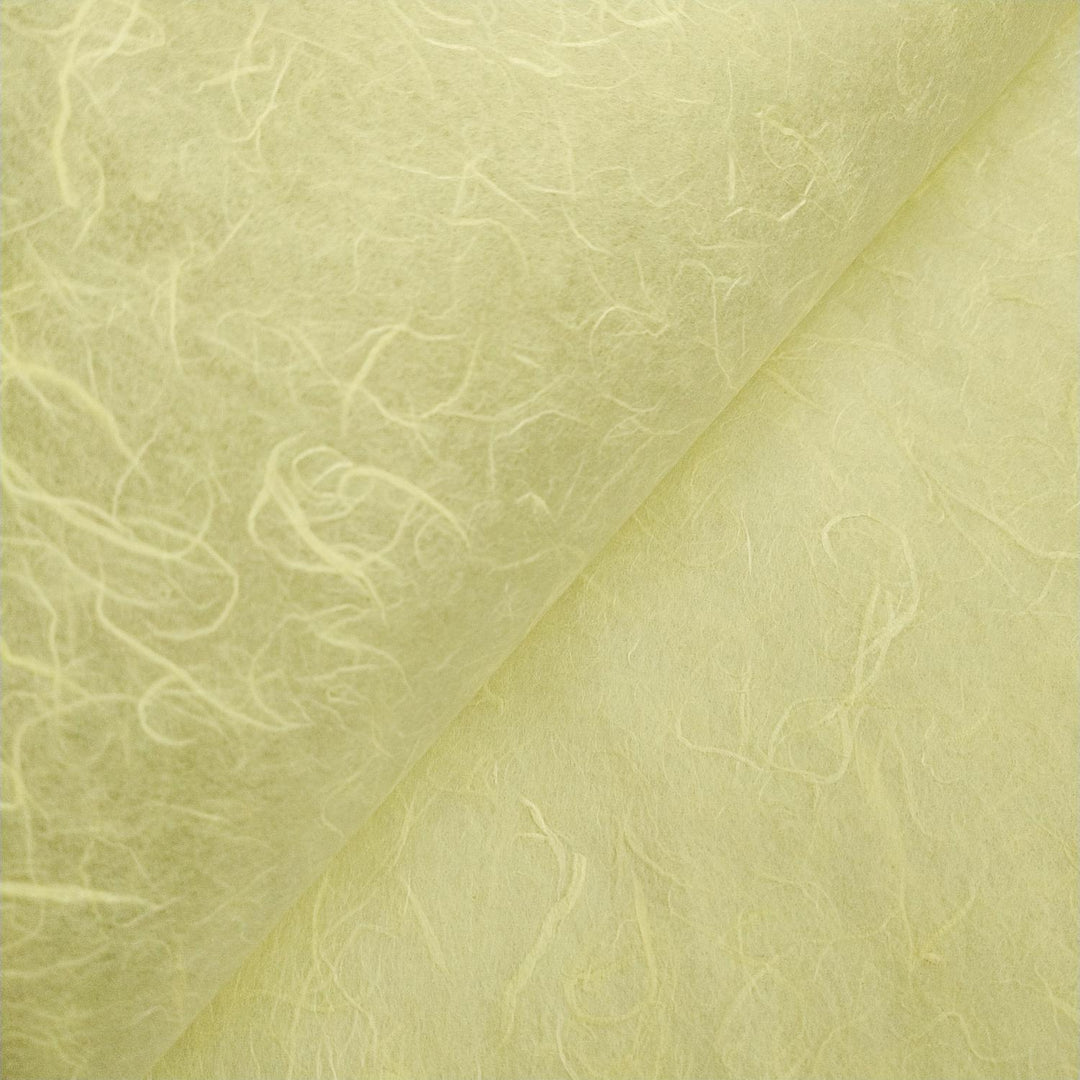 Macro shot of lemon yellow Unryu mulberry paper from Kozo Studio, emphasizing its texture and natural fiber inclusions.