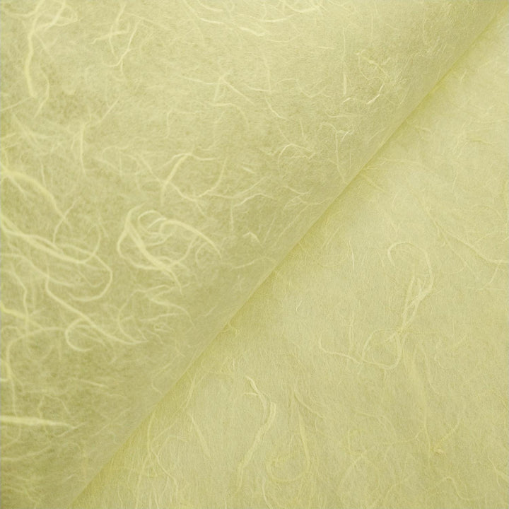 Macro shot of lemon yellow Unryu mulberry paper from Kozo Studio, emphasizing its texture and natural fiber inclusions.