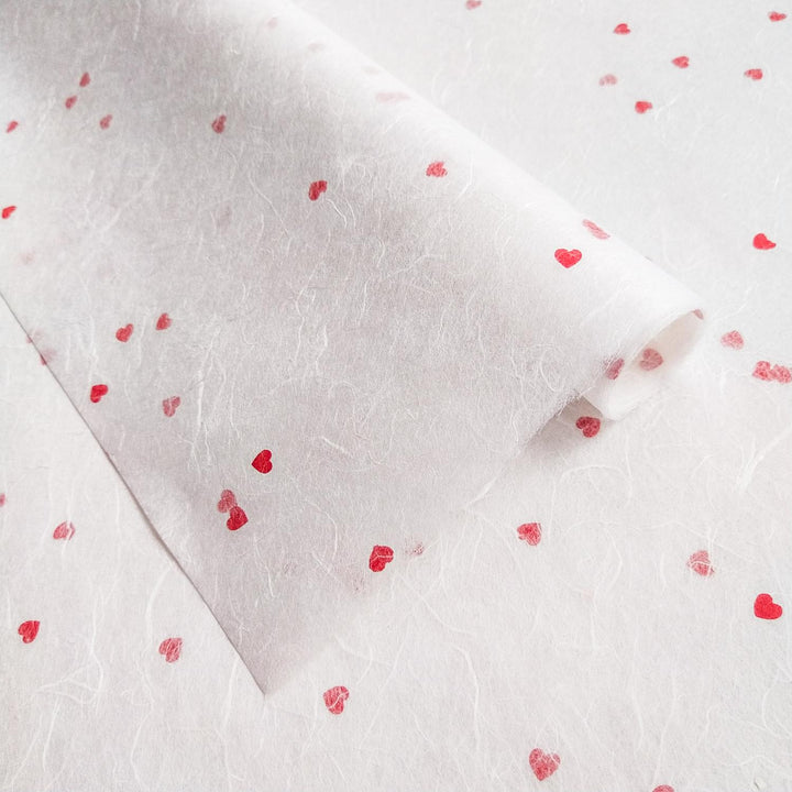 Handmade paper from Kozo Studio featuring white Unryu mulberry paper with small red hearts in a soft, romantic style.