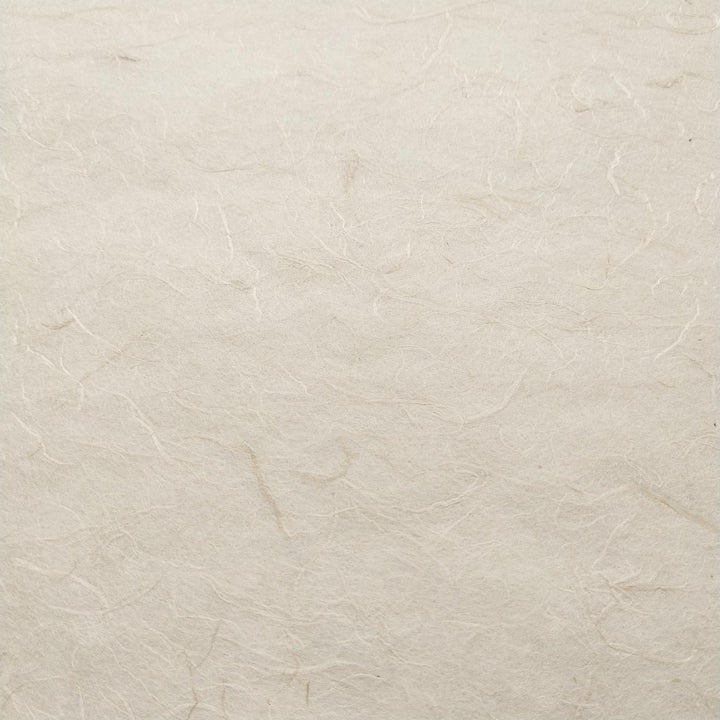 Close-up of Kozo Studio handmade paper featuring fibrous strands of mulberry paper on a natural off-white surface.