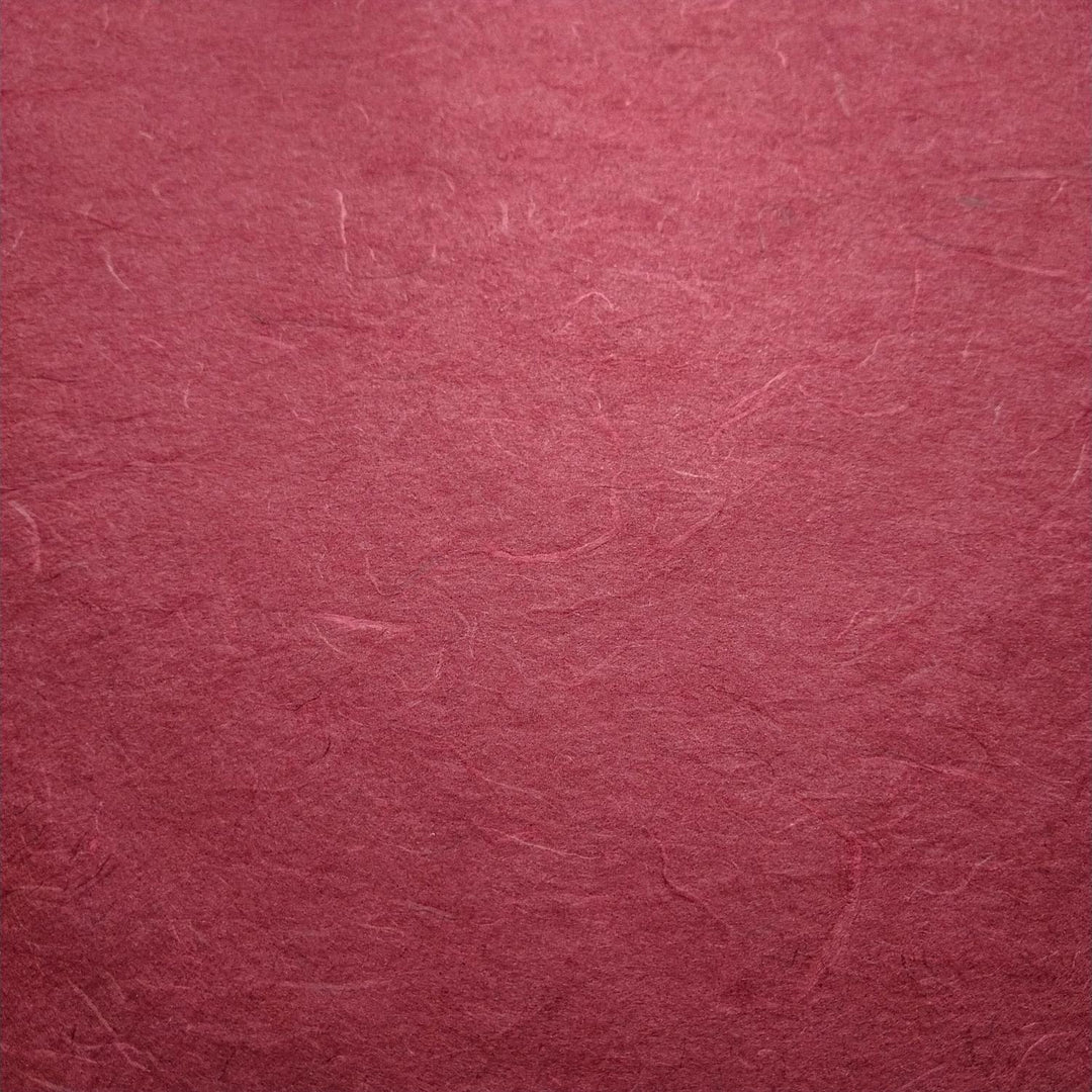 Diagonal layers of textured ruby wine Unryu Kozo Paper by Kozo Studio, highlighting the organic look of mulberry paper with delicate fiber patterns.