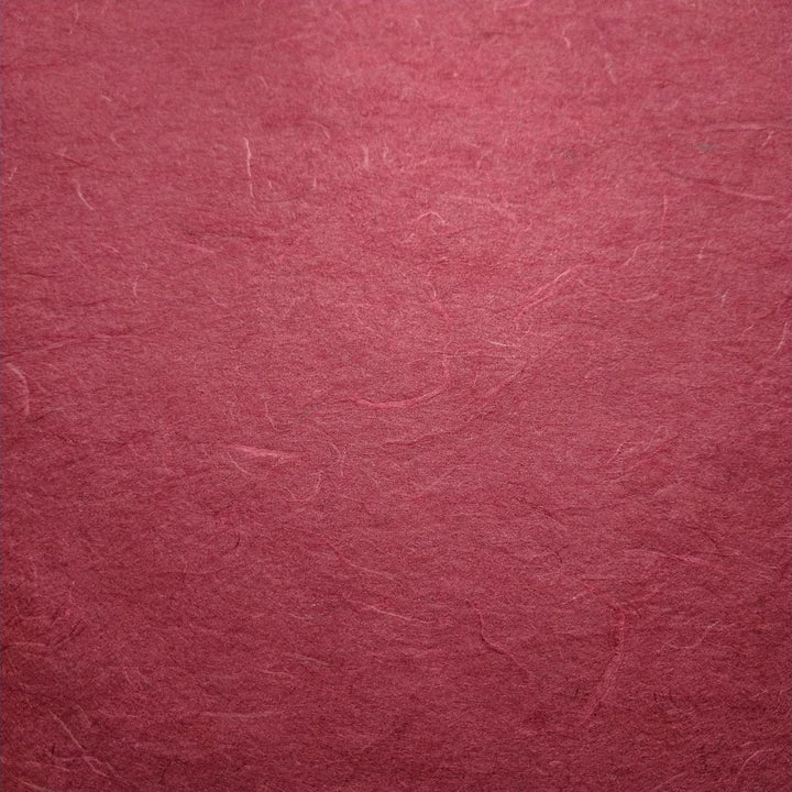 Diagonal layers of textured ruby wine Unryu Kozo Paper by Kozo Studio, highlighting the organic look of mulberry paper with delicate fiber patterns.