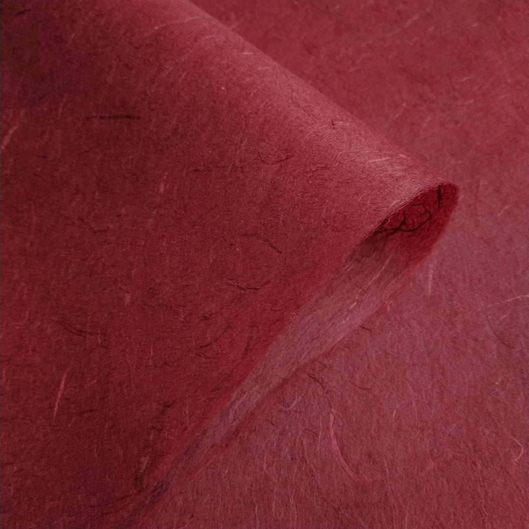 Artistic shot of Kozo Studio Unryu Paper in ruby wine color, resembling traditional mulberry paper with its handmade fiber-rich surface.