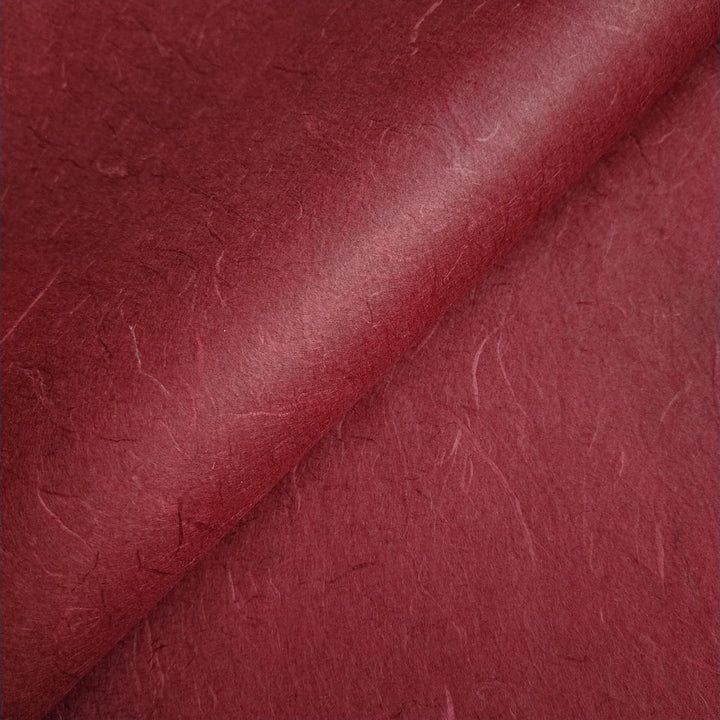 Ruby wine Unryu handmade paper from Kozo Studio displayed in layered diagonals, capturing the organic essence of mulberry paper.