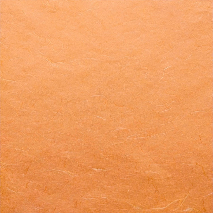Detailed view of Kozo Studio mulberry paper in vibrant orange, with delicate fibers and rich handmade paper texture.