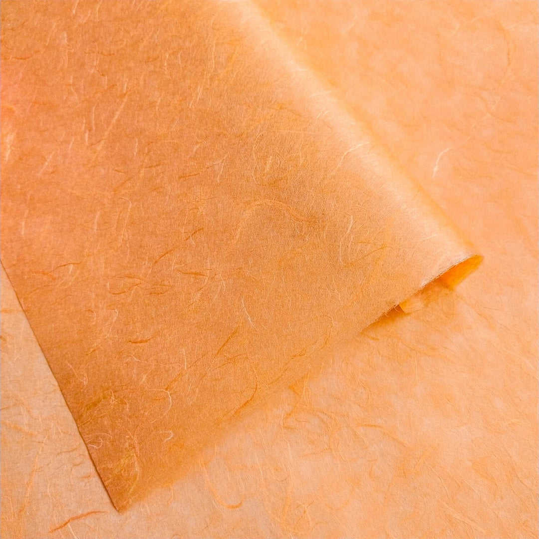 Tangerine orange Unryu paper from Kozo Studio, made from mulberry fiber, highlighting the intricate texture of traditional handmade paper.