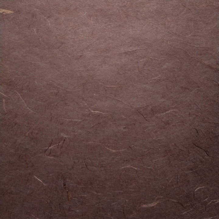 Detail view of artisanal Kozo Studio paper crafted from mulberry, featuring overlapping tawny brown handmade sheets.