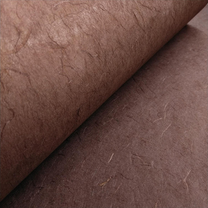 Rich brown handmade paper by Kozo Studio made from mulberry fiber, captured in a close-up with visible texture and organic layers.