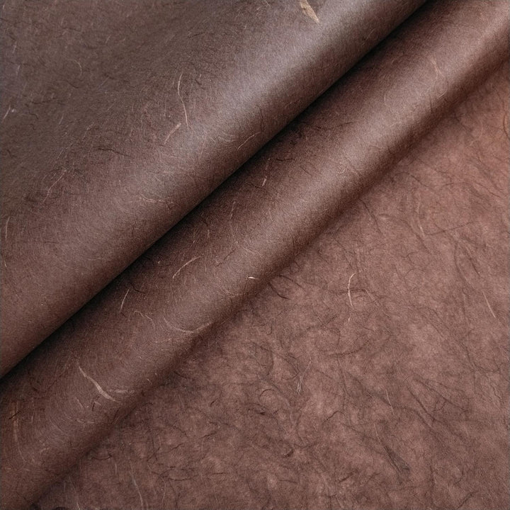 Close-up of overlapping tawny brown Unryu mulberry paper from Kozo Studio, showing fibrous texture and handmade paper details.