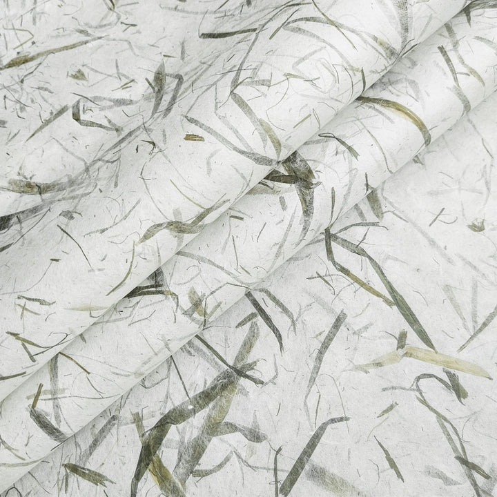 Close-up of Bamboo Leaf Kozo handmade paper from Kozo Studio, showcasing real bamboo leaves embedded in delicate mulberry paper with a soft, organic texture.