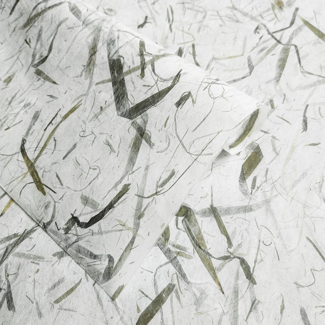 Organic, textured Kozo Studio mulberry paper with embedded bamboo leaves, capturing the natural elegance of traditional handmade paper in soft tones.