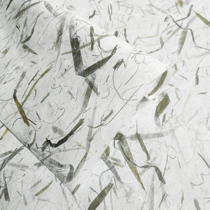 Organic, textured Kozo Studio mulberry paper with embedded bamboo leaves, capturing the natural elegance of traditional handmade paper in soft tones.