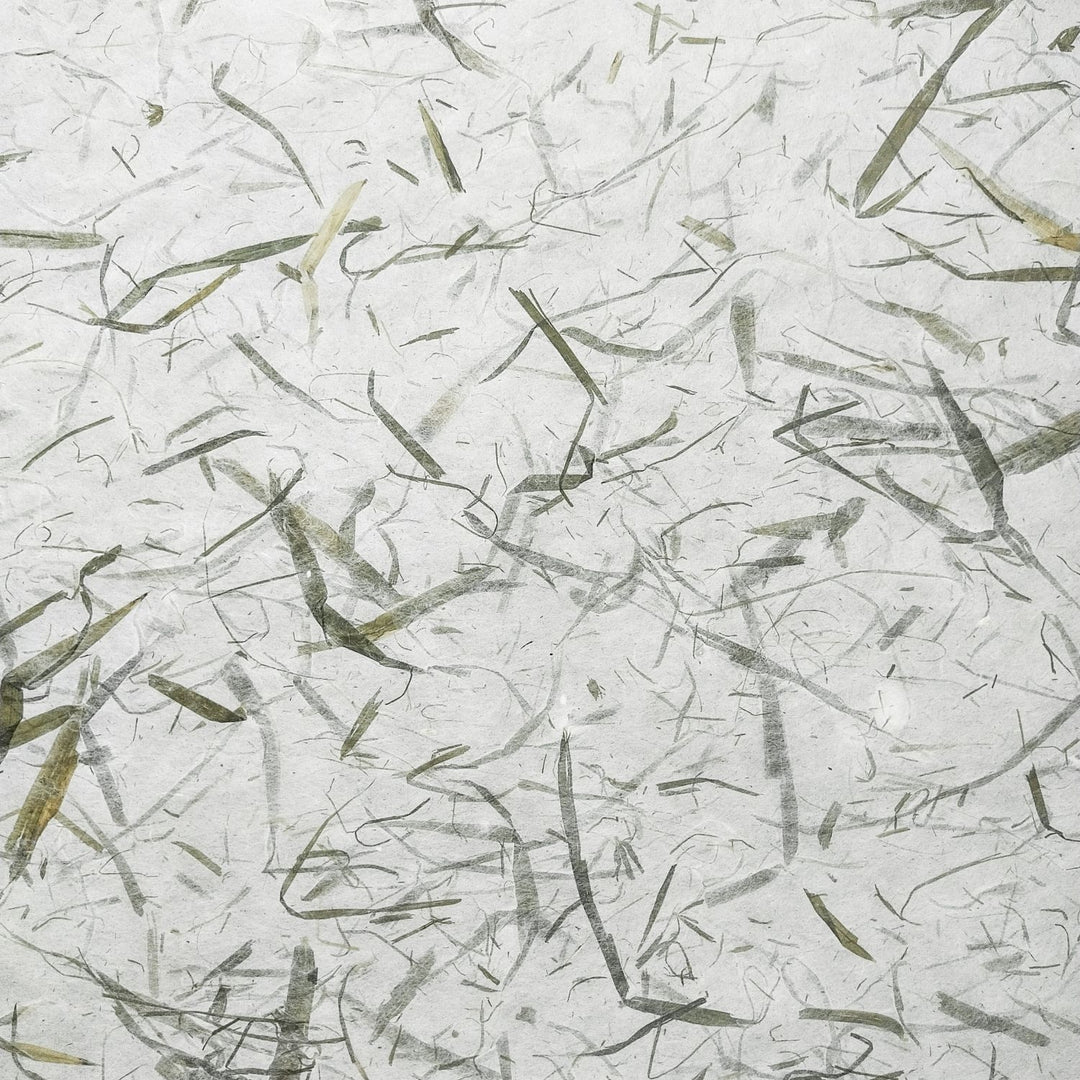 Handmade paper made from mulberry fibers featuring bamboo leaf patterns, photographed in detail to show the elegant design and texture by Kozo Studio.