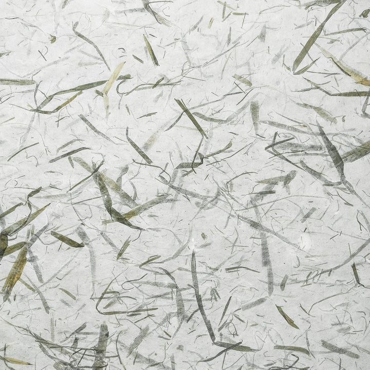Handmade paper made from mulberry fibers featuring bamboo leaf patterns, photographed in detail to show the elegant design and texture by Kozo Studio.