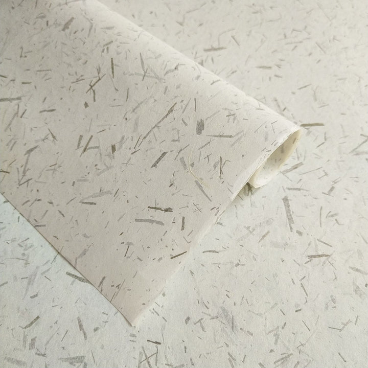 Handmade Bamboo Confetti Kozo paper by Kozo Studio showcasing a unique texture of natural fibers and bamboo leaf flecks, ideal for crafts and home decor.