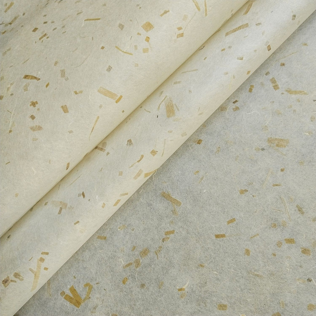 Close-up of Kozo Studio Coco Confetti Kozo Paper, a handmade mulberry paper with coconut leaf inclusions on a cream base and golden brown fibers for a natural, eco-friendly look.