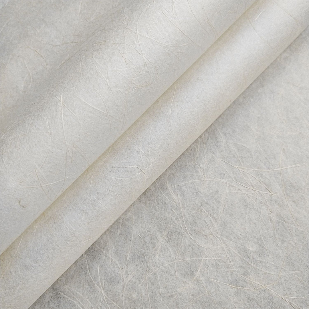 Close-up of Mikado Kozo handmade paper by Kozo Studio, showing off-white mulberry paper with fine hemp fibers and a lightly translucent, textured surface.