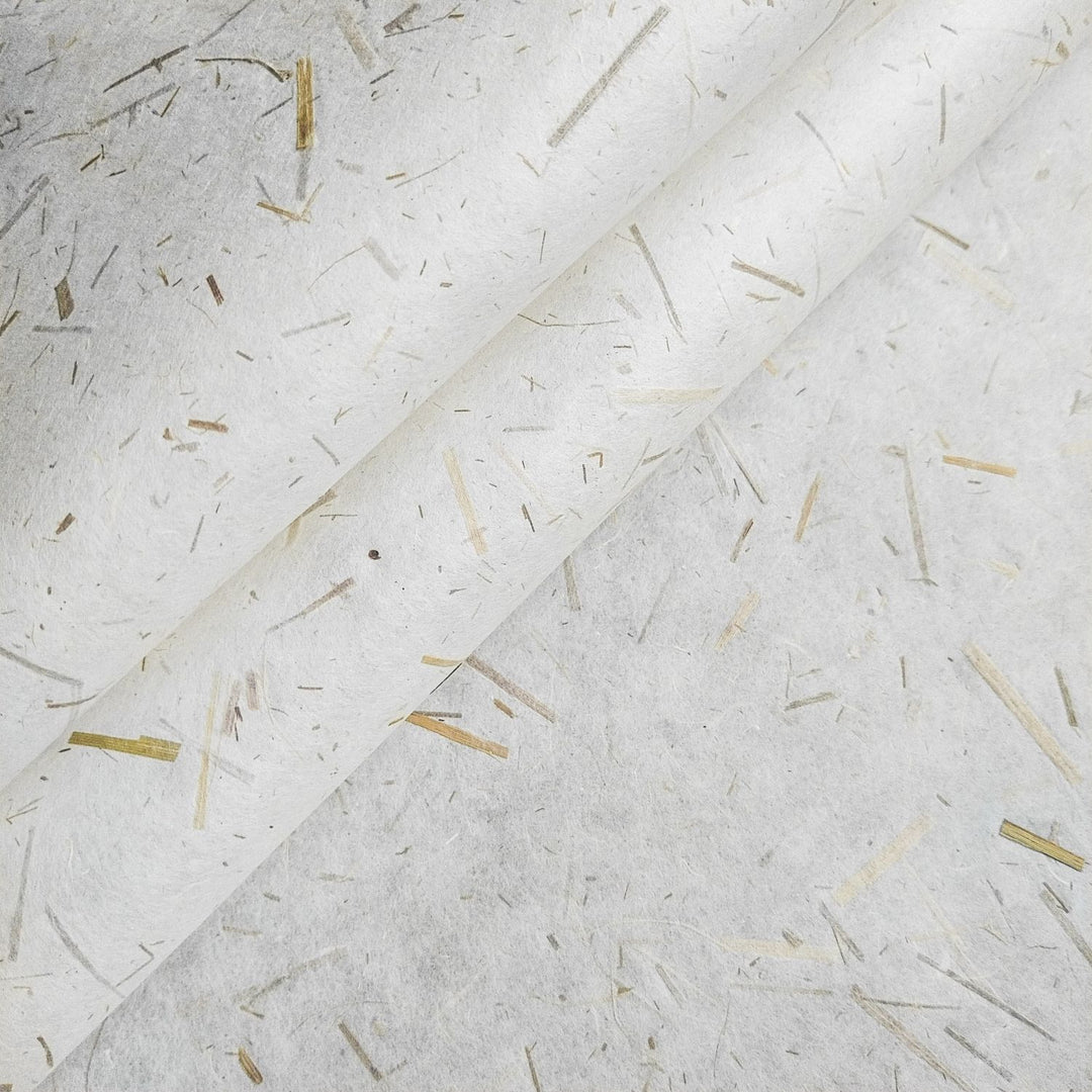 Close-up of sustainable mulberry paper with rice straw confetti, crafted by Kozo Studio, showcasing lightweight handmade paper ideal for creative projects.