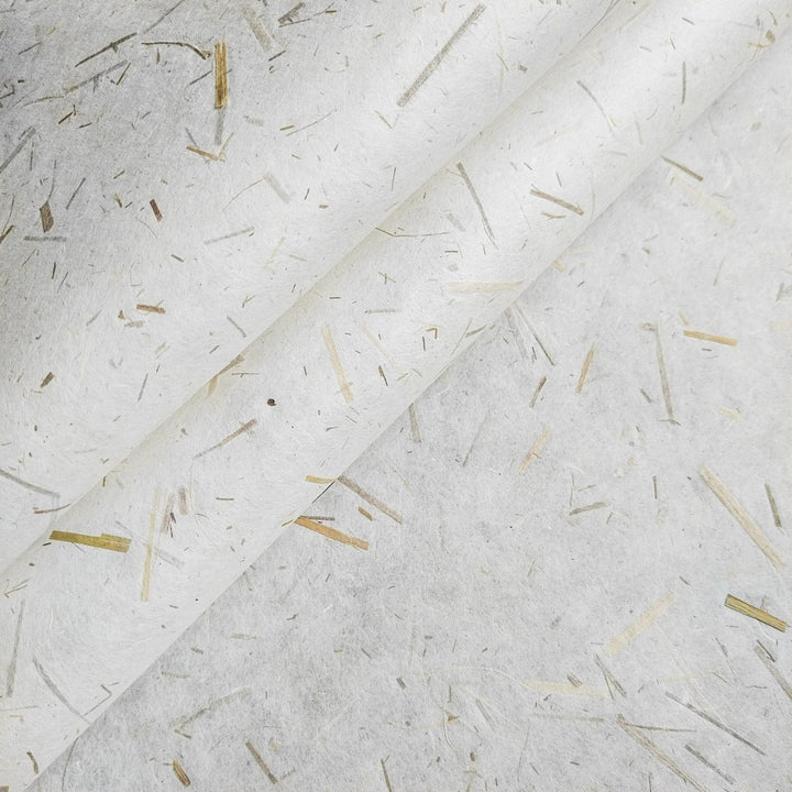 Close-up of sustainable mulberry paper with rice straw confetti, crafted by Kozo Studio, showcasing lightweight handmade paper ideal for creative projects.