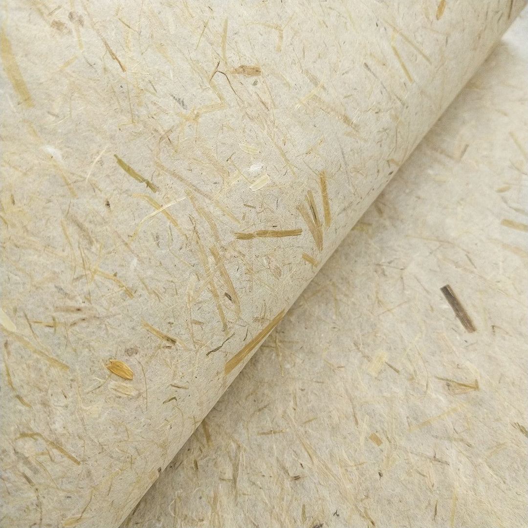 Organic-looking handmade paper by Kozo Studio, made with mulberry fibers and decorated with straw inclusions for a natural, eco-friendly appearance.