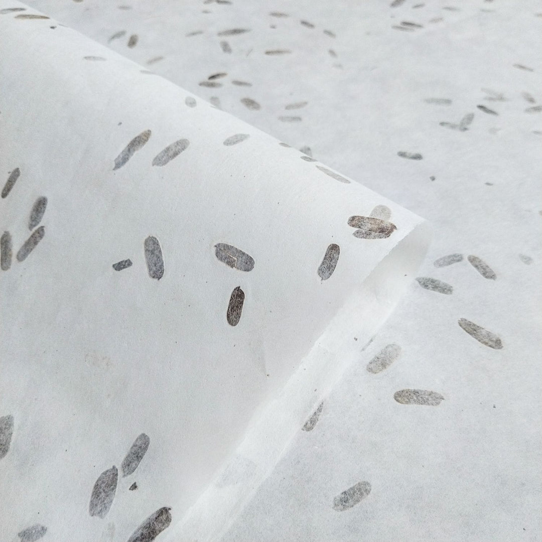 Kozo Studio's handmade mulberry paper with scattered tamarind leaves, forming a soft, layered texture and unique natural pattern.