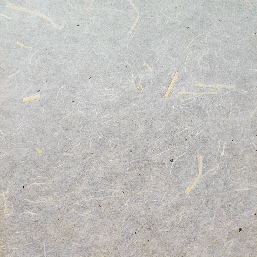 Detail shot of Kozo Studio handmade paper made from unbleached kozo fiber and mulberry bark, showing its light, textured, and semi-translucent finish.