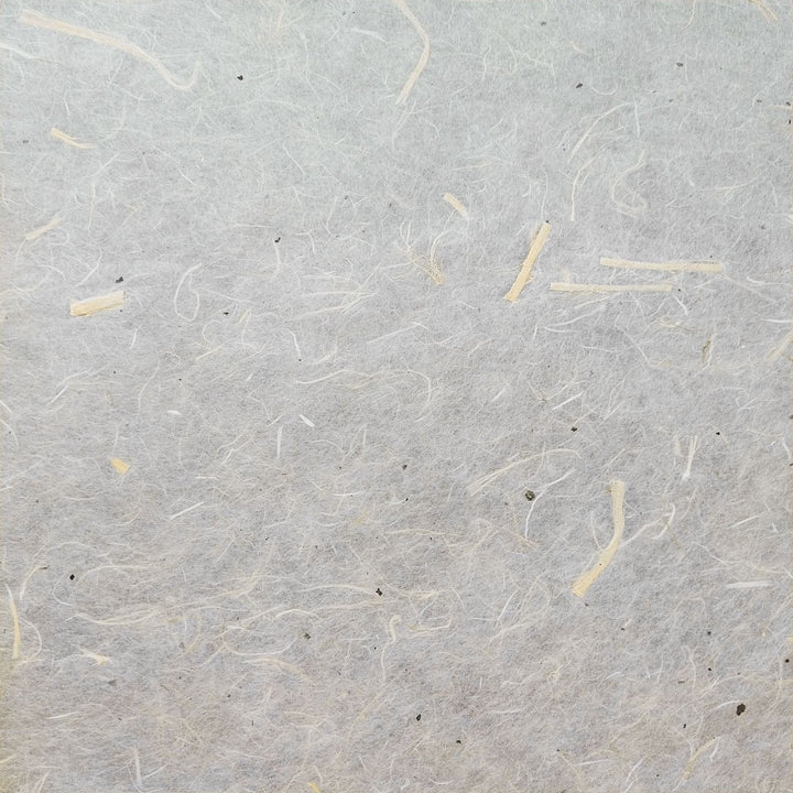 Detail shot of Kozo Studio handmade paper made from unbleached kozo fiber and mulberry bark, showing its light, textured, and semi-translucent finish.
