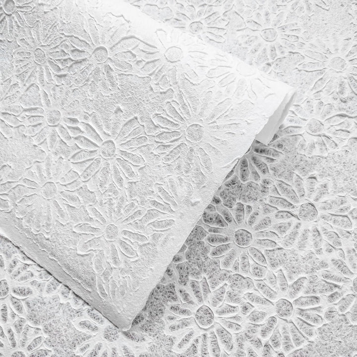 Embossed daisy-patterned mulberry paper from Kozo Studio, showcasing the Rakusui water-drop technique for a translucent handmade paper ideal for crafts and decor.