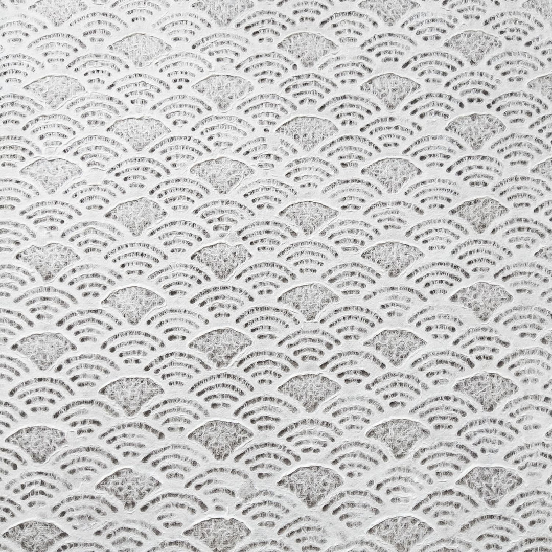 The handmade Lace Kozo Mulberry Paper (Fan) by Kozo Studio features an intricate pattern of overlapping semi-circles resembling fish scales or ocean waves on the delicate texture of rice paper, in uniform shades of white and gray.