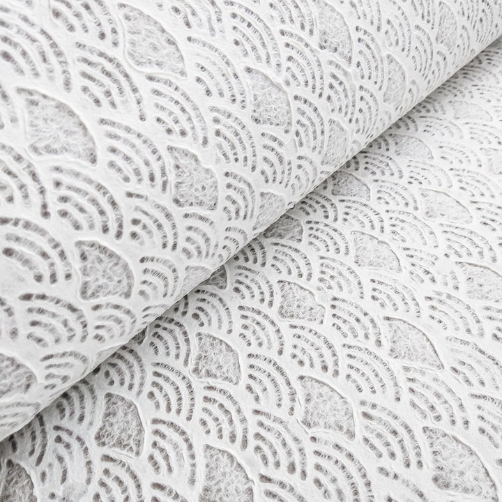 Handmade Lace Kozo Paper (Fan) by Kozo Studio offers rolls of textured white Mulberry paper with a fan pattern. The design features a detailed and intricate look with its slightly raised texture.
