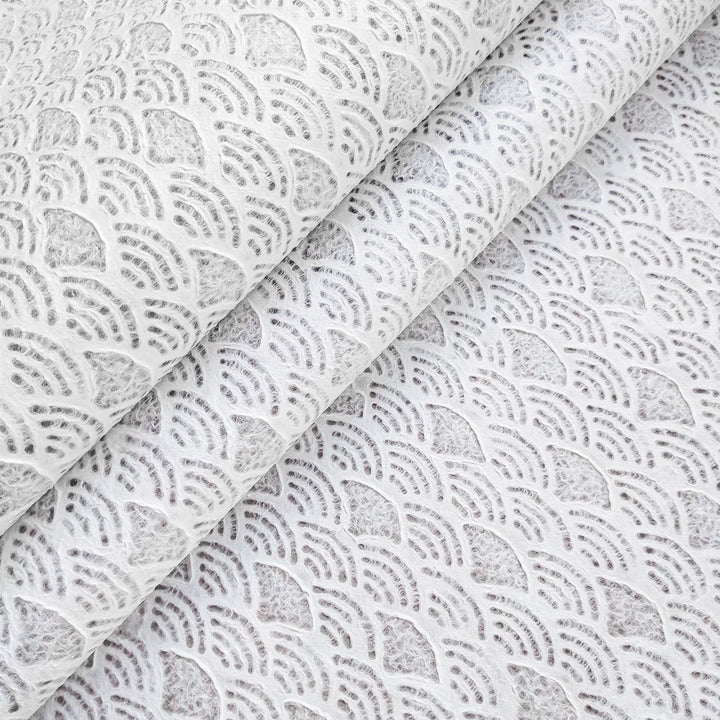 A close-up of Handmade Lace Kozo Mulberry Paper (Fan) from Kozo Studio reveals an intricate fan pattern, resembling overlapping seashells, creating a layered, three-dimensional effect with shadowed depth.