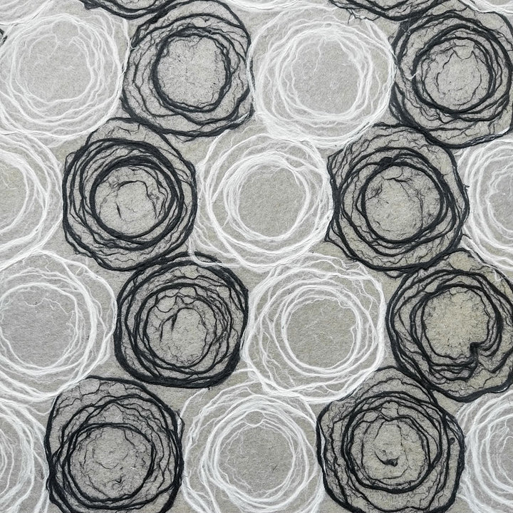 Kozo Studio handmade paper showcasing black and white circular rose motifs on lightweight mulberry paper, suited for design and DIY.