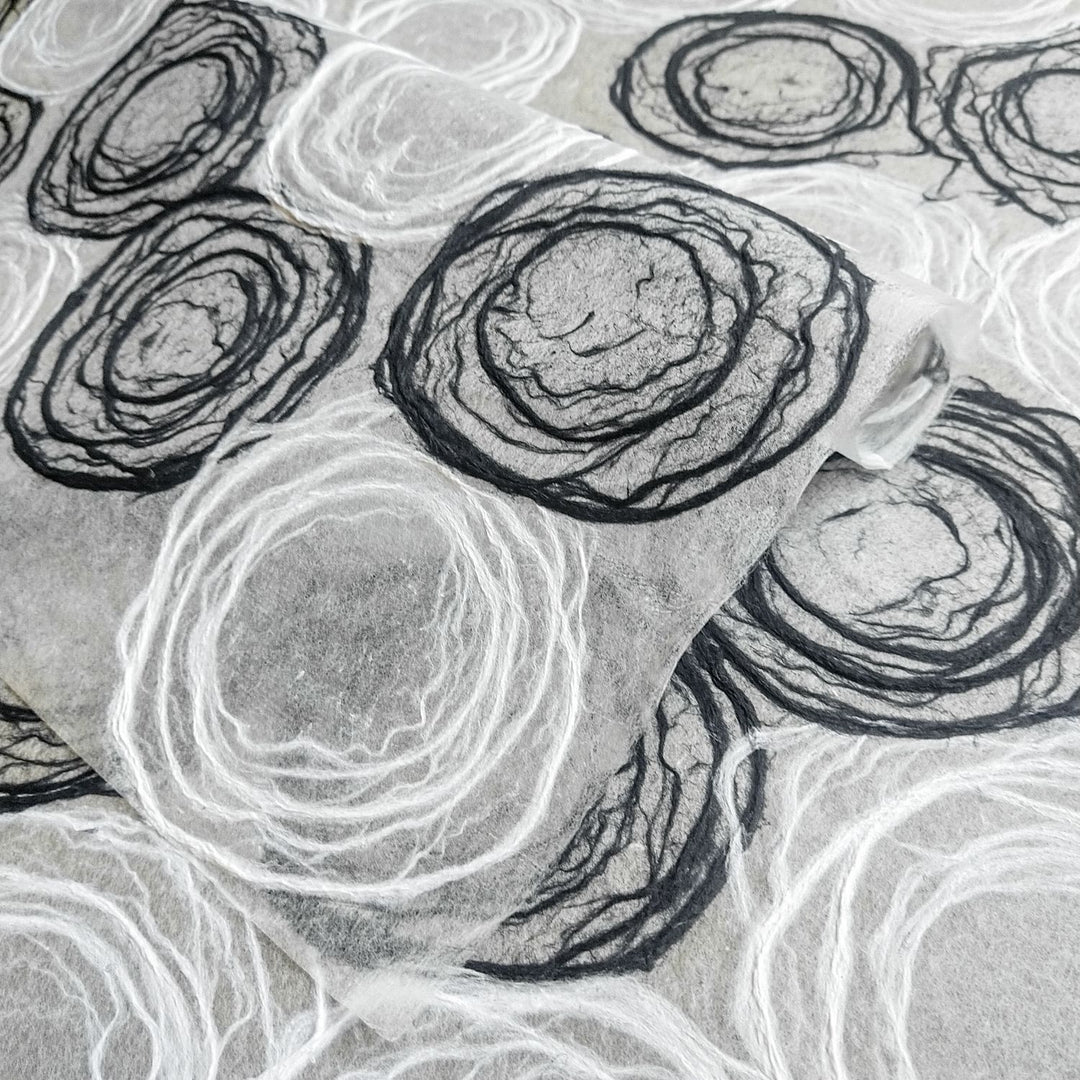 Artistic rose-patterned mulberry paper from Kozo Studio, made with hand-drawn pulp circles, perfect for elegant decor and crafts.