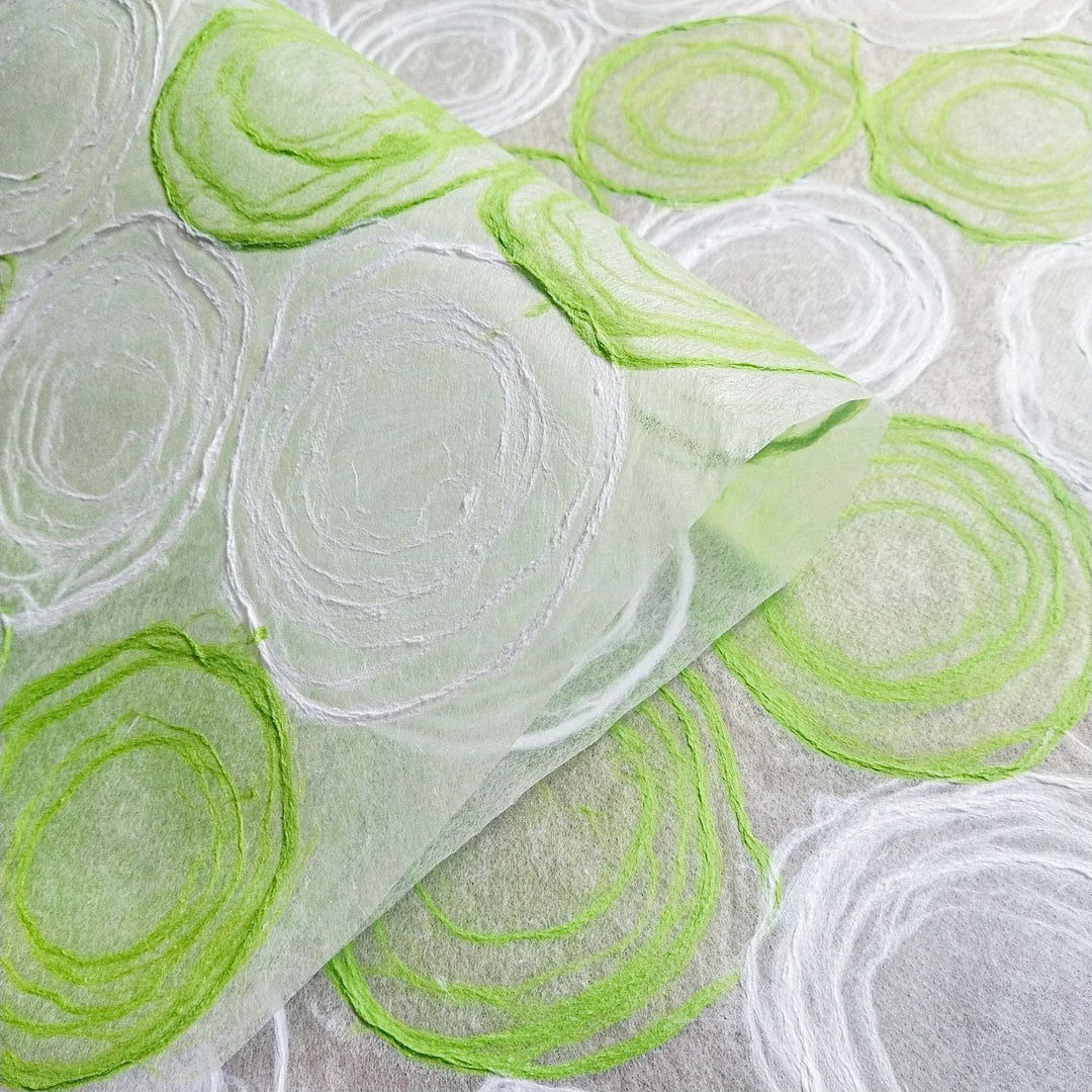 Elegant green and white kozo paper created by Kozo Studio, made from translucent mulberry paper with hand-applied pulp circles, great for lamps or crafts.