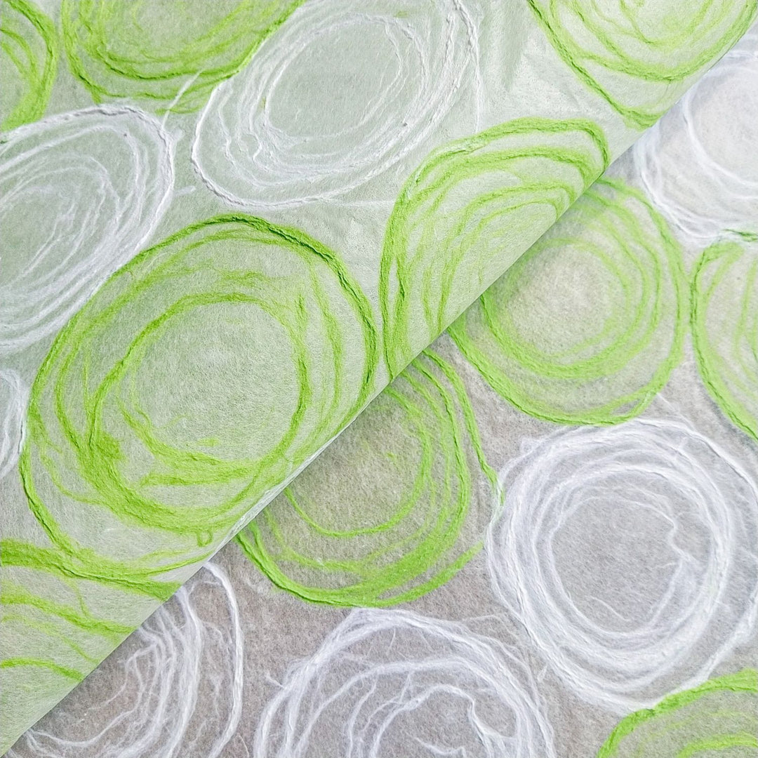 Green and white handmade paper from Kozo Studio, featuring delicate hand-drawn pulp circles on translucent mulberry paper, perfect for lamp and window shades.