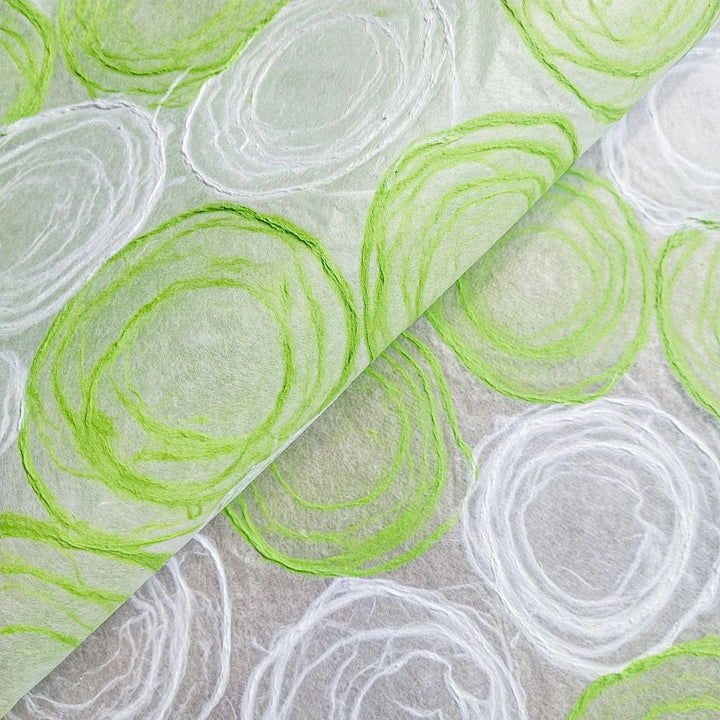 Green and white handmade paper from Kozo Studio, featuring delicate hand-drawn pulp circles on translucent mulberry paper, perfect for lamp and window shades.