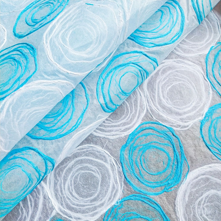 Detailed view of rose kozo paper made by hand on mulberry sheets, highlighting the artistic light blue and white pulp design from Kozo Studio.