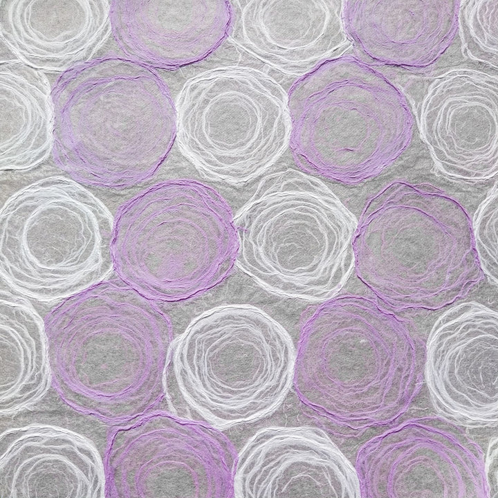 Translucent handmade mulberry paper in light purple and white, designed at Kozo Studio with hand-drawn pulp circles for unique art and DIY projects.