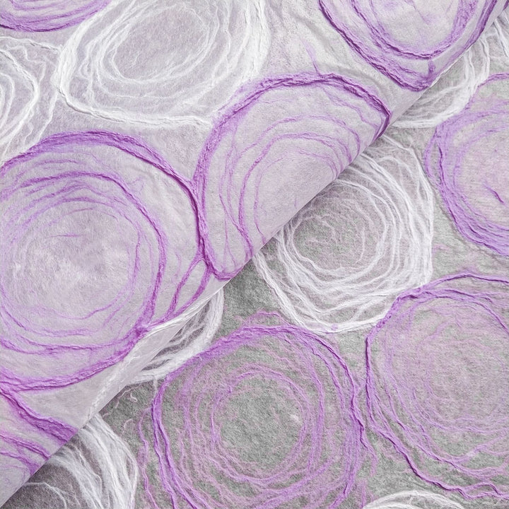 Light purple and white handmade paper with circular pulp patterns on thin mulberry paper, crafted at Kozo Studio for use in lamps, windows, or art projects.