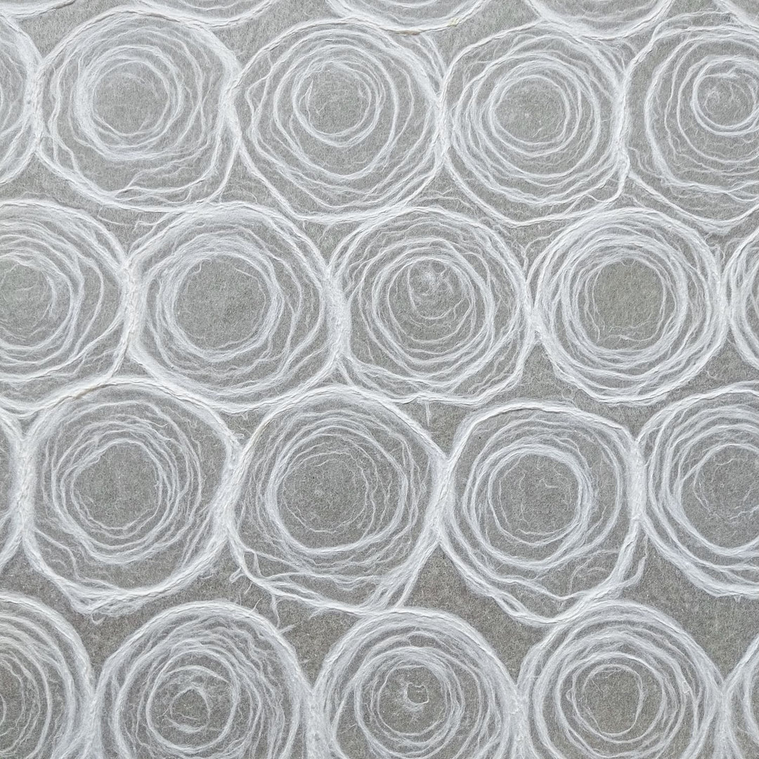 Elegant white handmade kozo paper from Kozo Studio with hand-drawn pulp circles on mulberry paper, perfect for decorative projects.