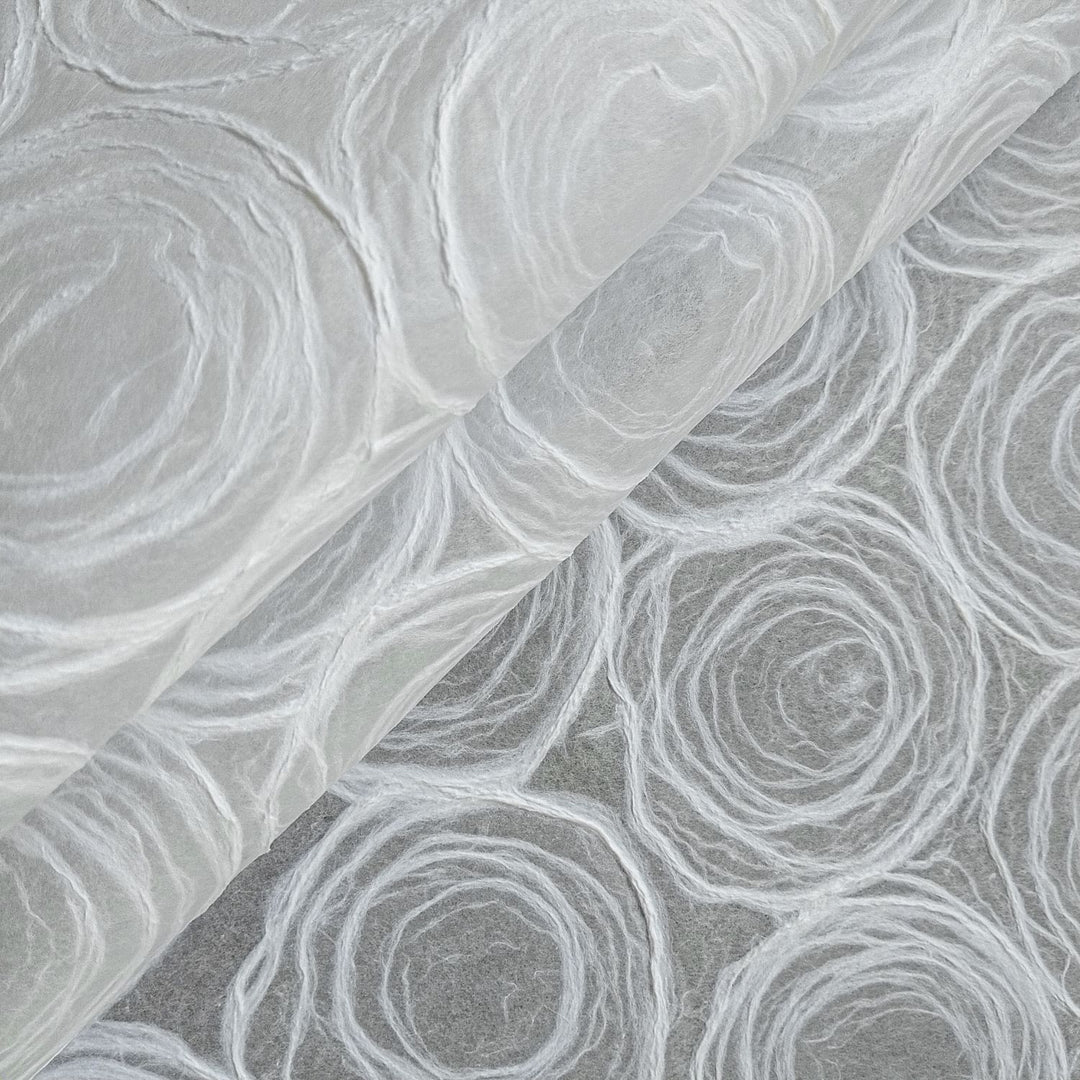 Translucent handmade paper with rose pulp designs by Kozo Studio, made from fine mulberry paper for versatile artistic use.