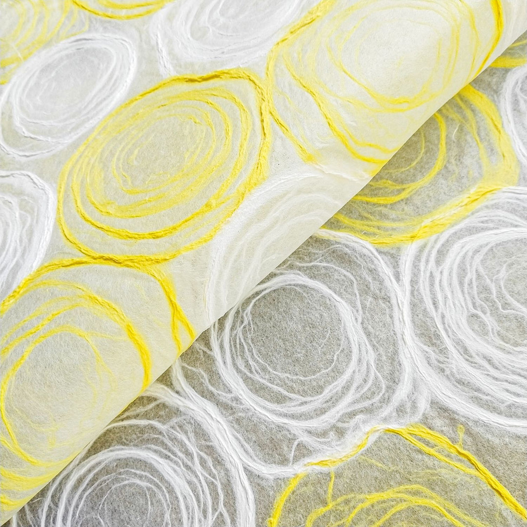 Yellow and white handmade paper with rose designs made from hand-drawn pulp circles on delicate mulberry paper, created at Kozo Studio for artistic and decorative use.