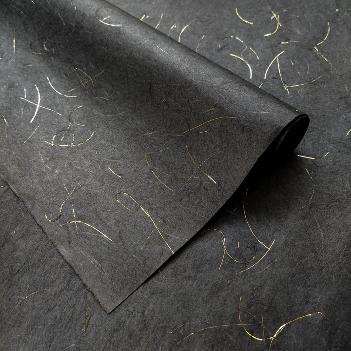 Detailed view of Golden Tinsel Unryu Kozo paper from Kozo Studio, highlighting the elegant black mulberry paper and shimmering gold fibers embedded in its handmade texture.