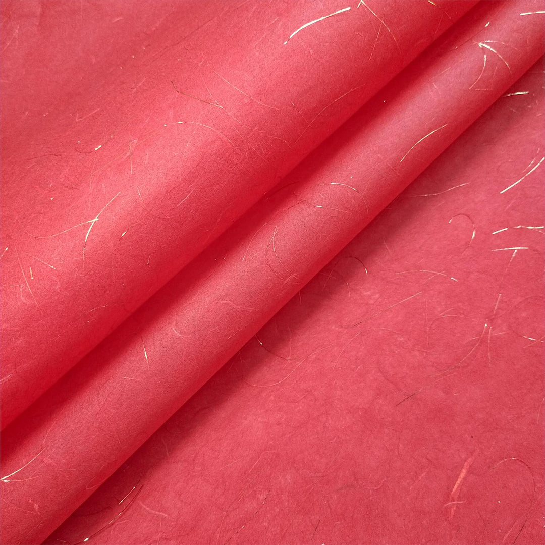 Close-up of handmade mulberry paper from Kozo Studio, featuring delicate kozo fibers and golden tinsel strands for a luxurious, translucent finish.